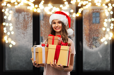 Image showing teenage girl in santa hat with christmas gift