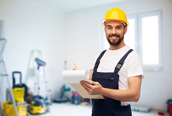 Image showing male worker or builder in helmet with clipboard