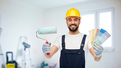 Image showing male builder with paint roller and color palettes