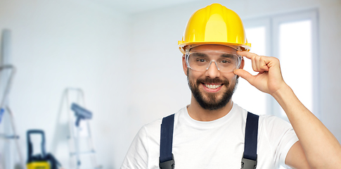 Image showing happy male worker or builder in helmet and overall