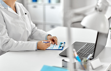 Image showing doctor with laptop and medical report at hospital