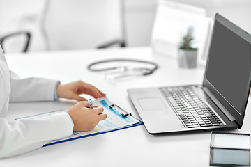 Image showing doctor with laptop and medical report at hospital