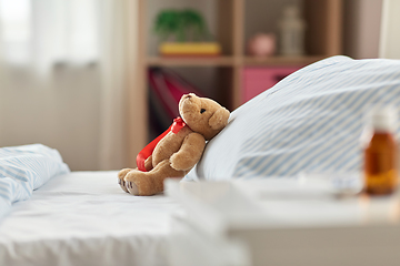 Image showing teddy bear toy in bed and medicine at home