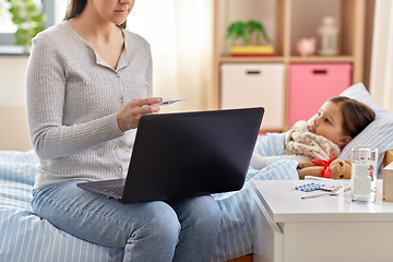 Image showing mother measuring temperature of sick daughter