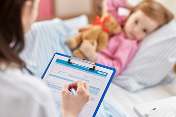 Image showing doctor with clipboard and sick girl in bed at home