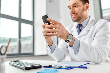 Image showing smiling male doctor with smartphone at hospital