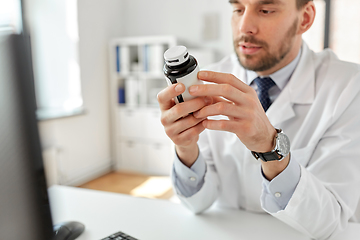 Image showing smiling male doctor with medicine at hospital