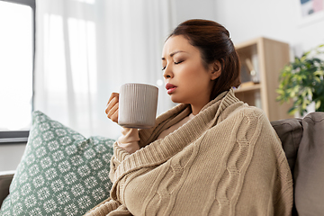 Image showing sick asian woman drinking hot tea at home
