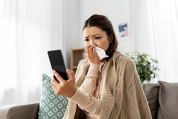 Image showing sick woman having video call on smartphone at home