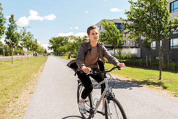 Image showing young man riding bicycle on city street