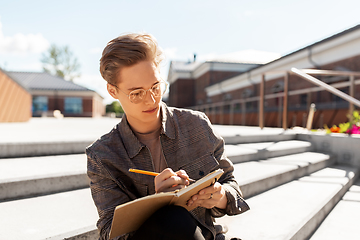 Image showing young man with notebook or sketchbook in city