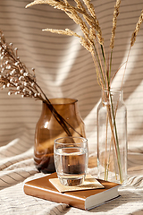 Image showing glass of water, decorative dried flowers in vases