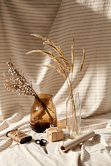 Image showing gift wrapping, dried flowers in vases on drapery