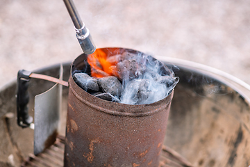 Image showing Coal heater on a grill with a gas flame