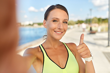 Image showing sporty woman taking selfie and showing thumbs up