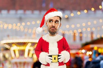 Image showing sad man in santa claus costume at christmas market