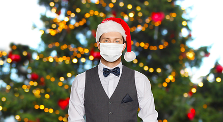 Image showing man in protective masks and santa hat on christmas