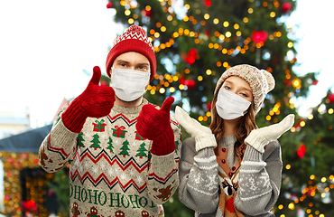 Image showing couple in protective masks and christmas sweaters