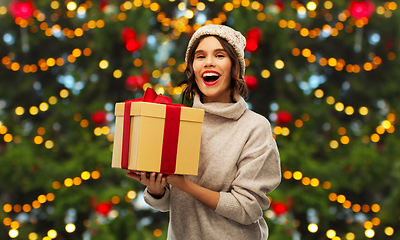 Image showing happy young woman holding christmas gift