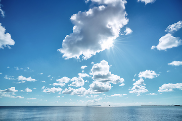 Image showing Seascape wit the sun hiding behind a cloud