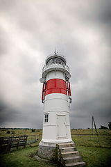 Image showing Small lighthouse on a green field in cloudy weather