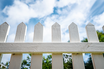 Image showing White picket fence under a blue sky