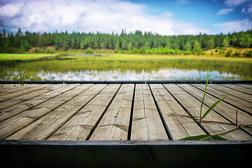 Image showing Wooden pier with planks at an idyllic lake