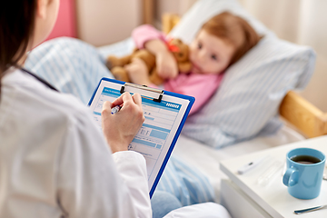 Image showing doctor with clipboard and sick girl in bed at home