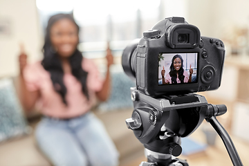 Image showing female blogger with camera video blogging at home