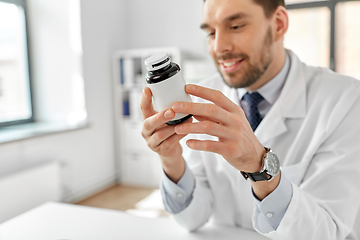 Image showing smiling male doctor with medicine at hospital