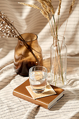 Image showing glass of water, decorative dried flowers in vases