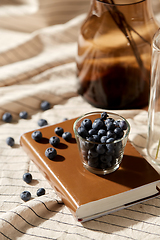 Image showing cup of blueberry, book and dried flowers in vases