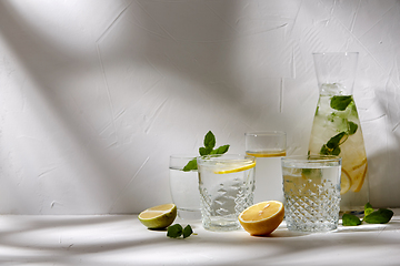 Image showing glasses with lemon water and peppermint on table