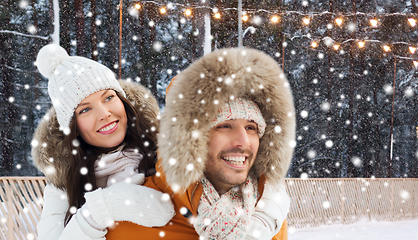 Image showing happy couple over ice skating rink background