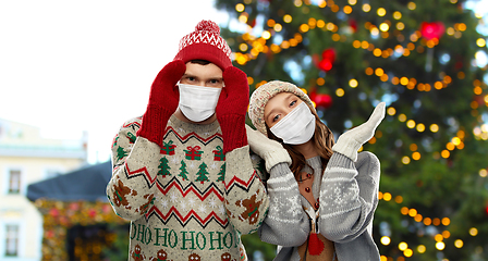 Image showing couple in protective masks and christmas sweaters