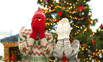 Image showing couple in ugly sweaters and mittens on christmas