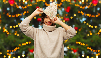 Image showing happy woman in knitted hat over christmas tree