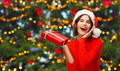 Image showing happy young woman in santa hat with red gift box