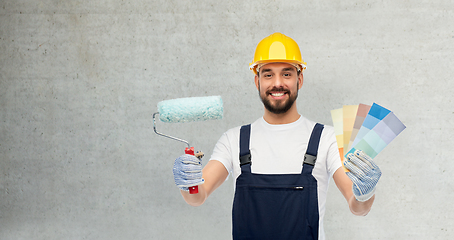 Image showing male builder with paint roller and color palettes