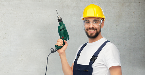 Image showing happy male worker or builder in helmet with drill