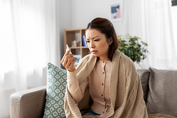 Image showing sick asian woman with nasal spray medicine at home