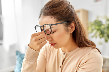 Image showing tired asian woman with glasses rubbing nose bridge