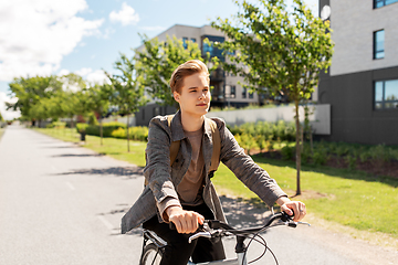 Image showing young man riding bicycle on city street