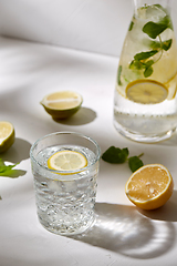 Image showing glasses with lemon water and peppermint on table