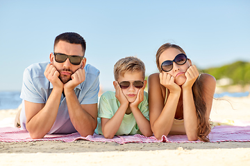 Image showing unhappy family lying on summer beach