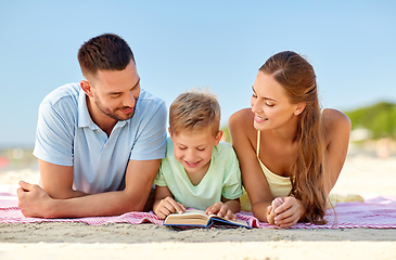 Image showing happy family reading book on summer beach