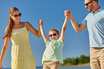 Image showing happy family walking along summer beach