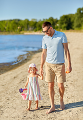 Image showing happy father walking with little daughter on beach