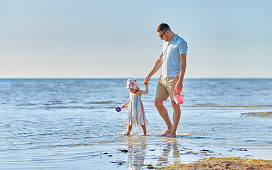 Image showing happy father walking with little daughter on beach