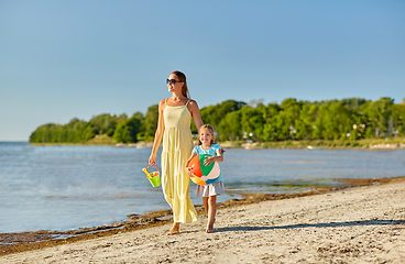 Image showing mother and daughter with ball walking along beach